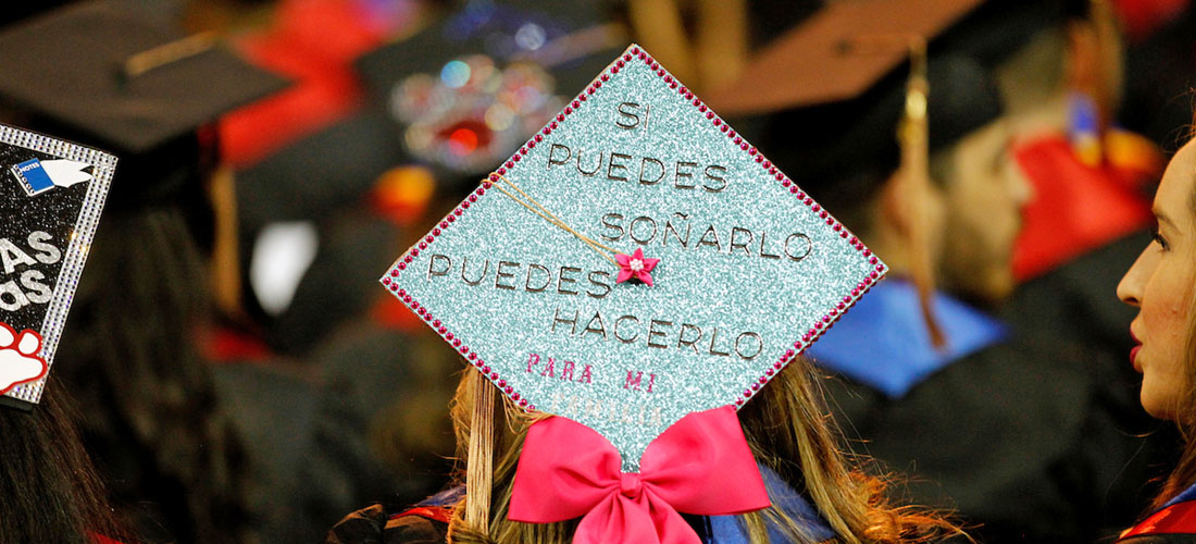 Detail shot of the back of a female graduate's mortarboard, which reads in Spanish "Si puedes soñarlo, puedes hacerlo. Para mi." (If you can dream it, you can do it. For me.)