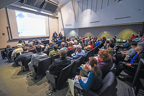 The Alice Peters Auditorium (PB 191) in the University Business Center. A large crowd attends a lecture.