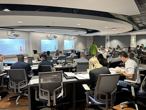 The Executive Classroom (PB 192) at the University Business Center. Seminar students fill tiered seating.