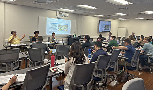 A group of students listens to a speaker in PB 194, the multi-purpose classroom in the University Business Center.